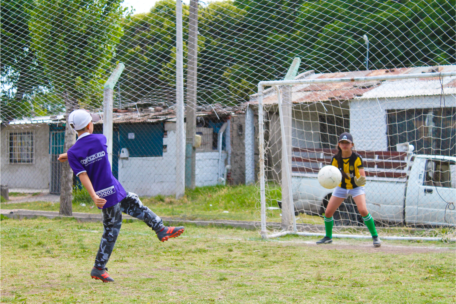 Un niño y una niña jugando fútbol
