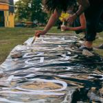 brazos de mujeres pintando una pancarta
