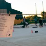 poemas colgando de una cuerda y al fondo personas haciendo ejercicio