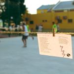 poemas colgando de una cuerda y adolescentes de al fondo jugando al basquetbol
