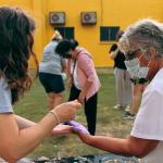 mujeres pintandose las manos mutuamente