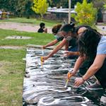 mujeres pintando una parcarta