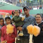 Una familia integrada por tres niñas, la madre y el padre posan con algodones de azúcar