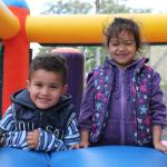 Un niño y una niña pequeña juegan en el inflable