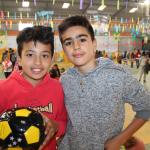 Dos niños se abrazan, uno tiene una pelota