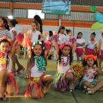 Niñas con vestimenta colorida y patines levantan las manos