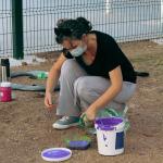 mujer con pintura violeta en un balde 