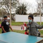 niño jugando al ping pong en frente a la mesa del juego