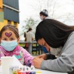 adolescente pintandole las uñas a una niña 