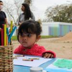 niña mirando hoja y crayolas