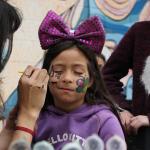 niña con ojos cerrado pintandose la cara
