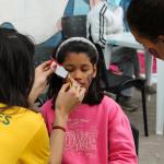 adolescente pintabdole la cara a una niña