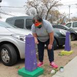 mujer pintando pinos de estacionamiento pintados de colores