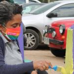 mujer pintando pinos de estacionamiento pintados de colores