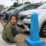 niño pintando pinos de estacionamiento pintados de colores