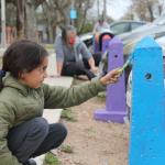 niño pintando pinos de estacionamiento pintados de colores