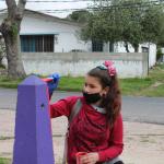 adolescente pintando pinos de estacionamiento pintados de colores