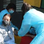 mujer enfermera tomando la presion a otra mujer