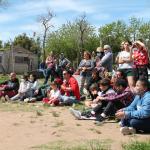 muchas personas de diferentes edades mirando una obra sentadas en la plaza
