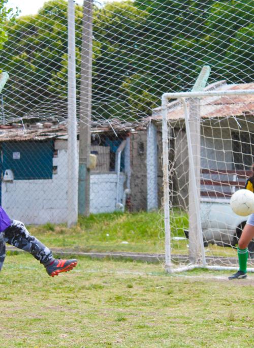 Un niño y una niña jugando fútbol