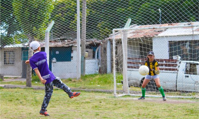 Un niño y una niña jugando fútbol