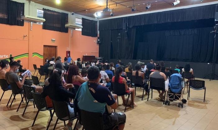 Publico de espaldas frente a un escenario con una función a punto de comenzar 