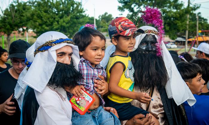 Dos niños se sacan una foto junto a dos de los reyes magos