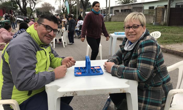 hombre y mujer jugando alrededor de una mesa sentados