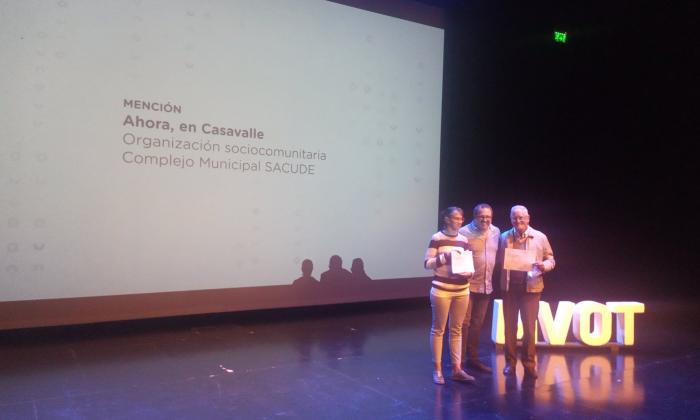 Tres personas posan con diplomas en la entrega del premio