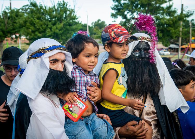 Dos niños se sacan una foto junto a dos de los reyes magos