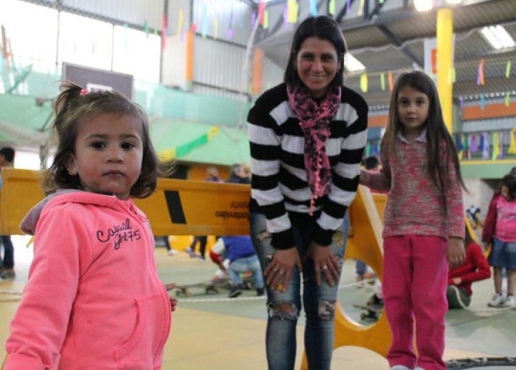 Tres niñas juegan con su madre y miran a la cámara