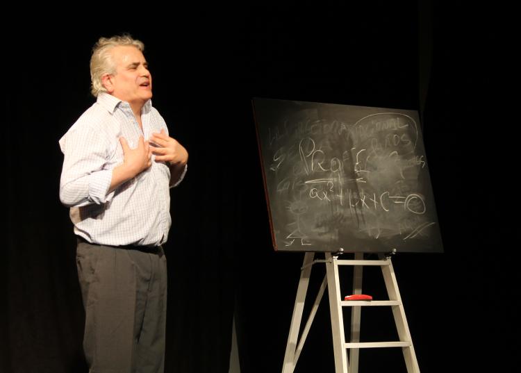 Un actor interpreta a un profesor, se lo ve junto a una pizarra