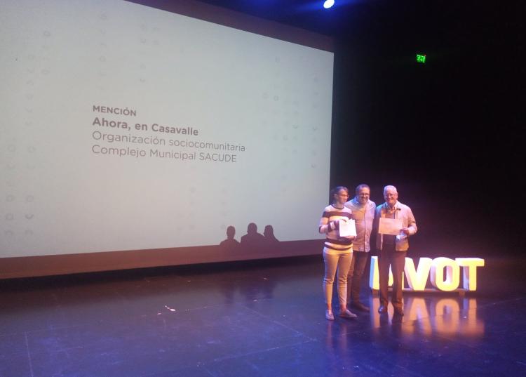 Tres personas posan con diplomas en la entrega del premio