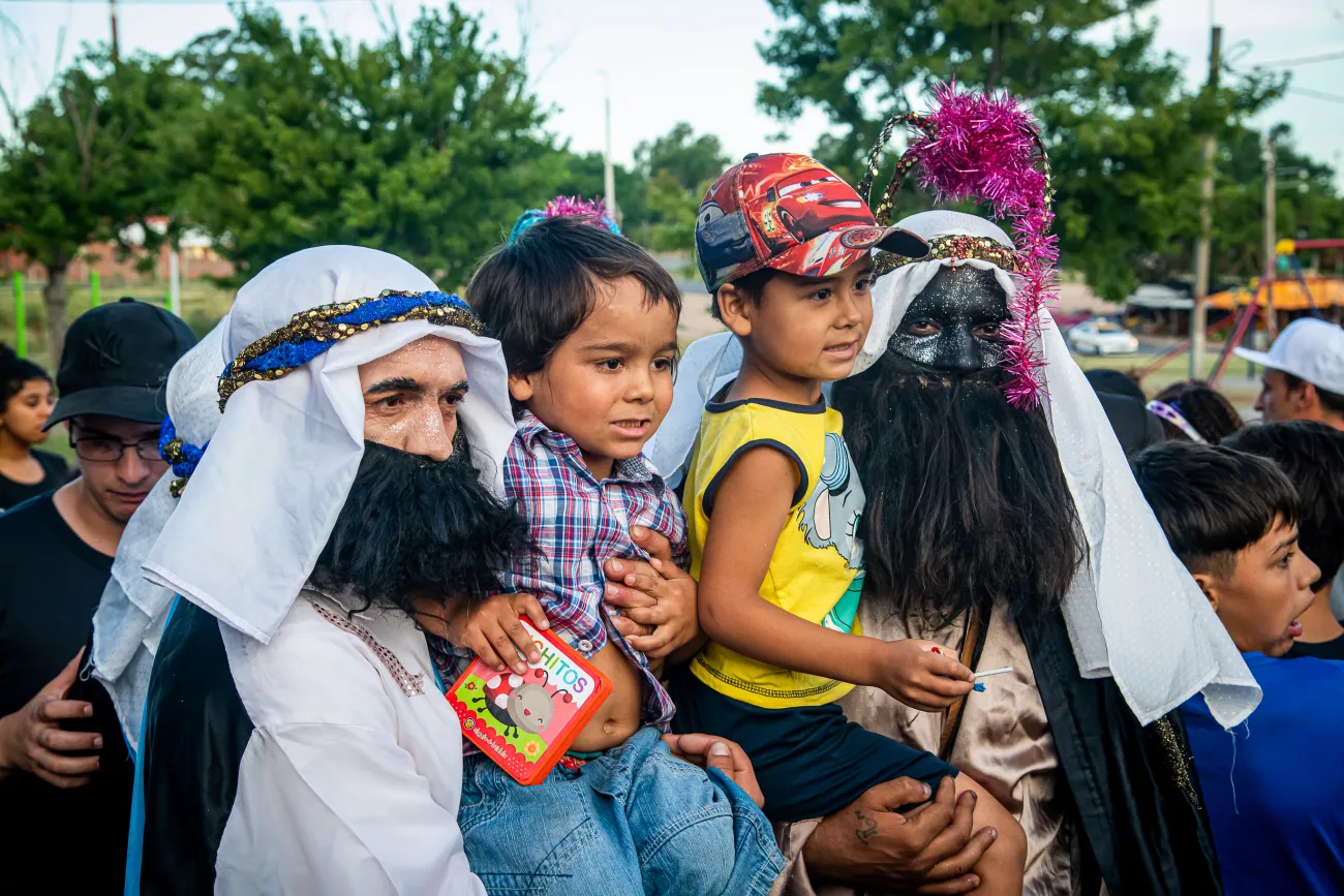 Dos niños se sacan una foto junto a dos de los reyes magos