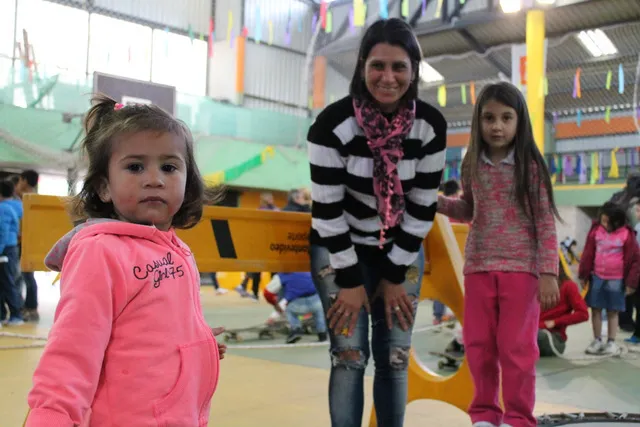 Tres niñas juegan con su madre y miran a la cámara
