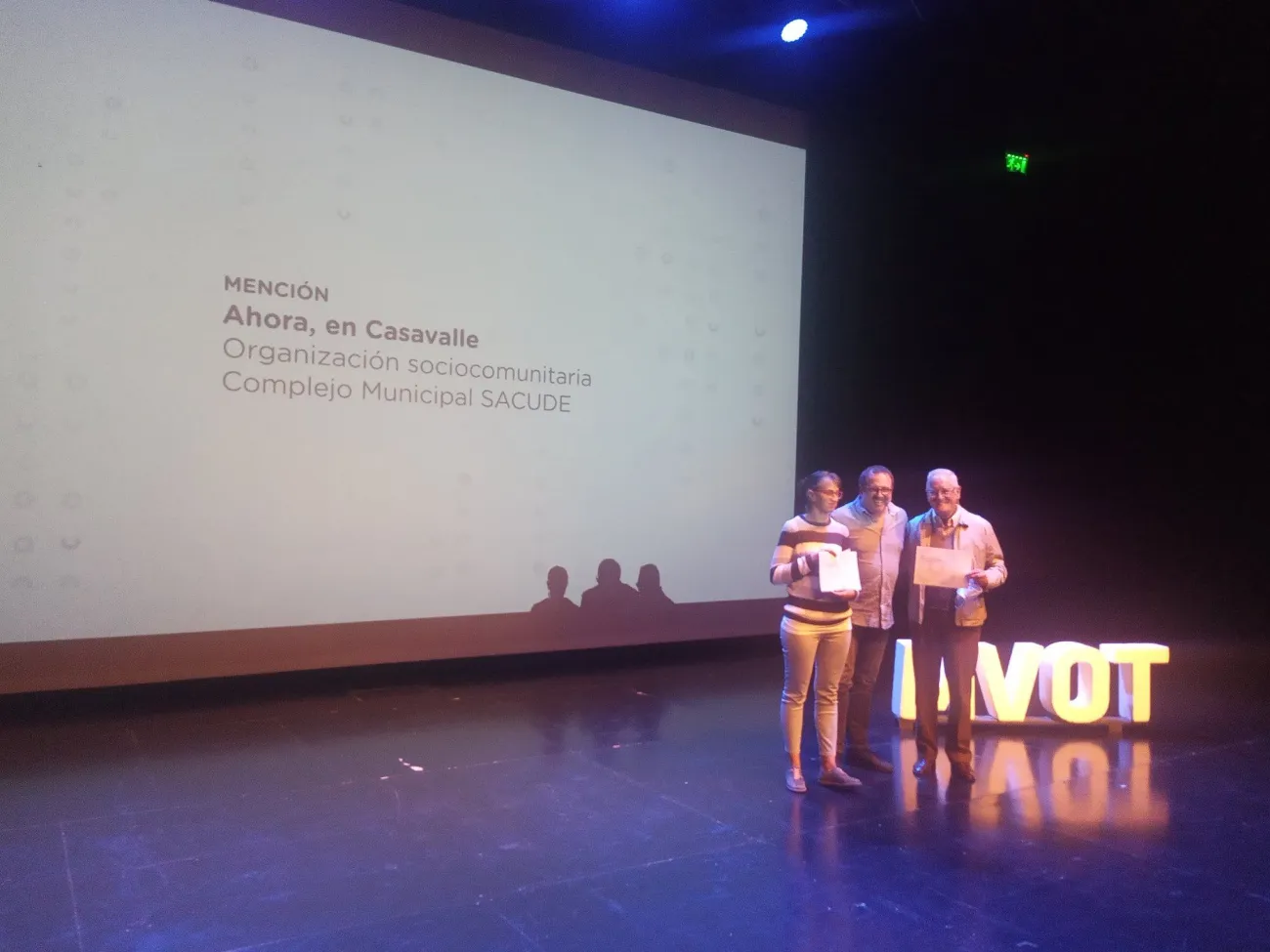 Tres personas posan con diplomas en la entrega del premio